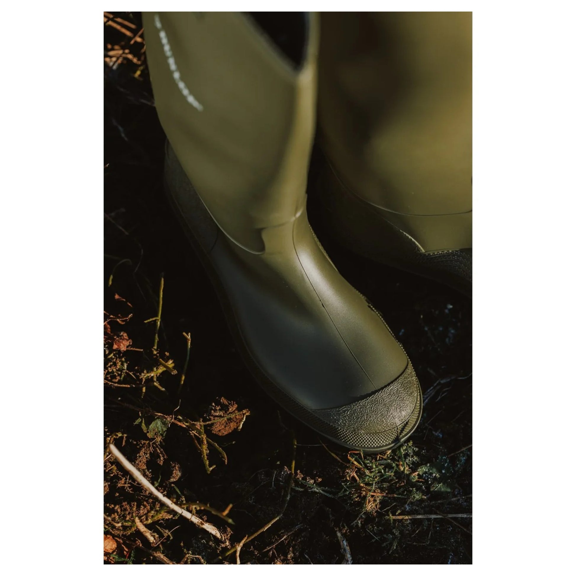 men's Dunlop green wellington boots on muddy ground – durable waterproof footwear for outdoor use