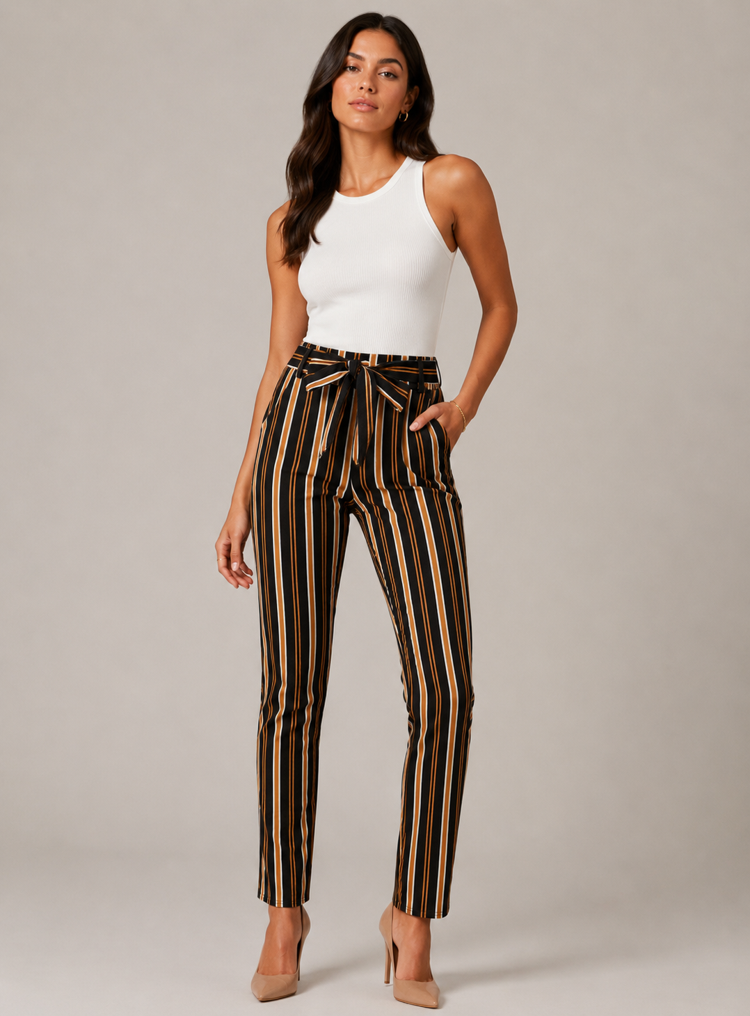 Women's high-waisted belted trousers in black with vertical tan, white, and orange stripes, featuring a tie-front waist and slim fit.