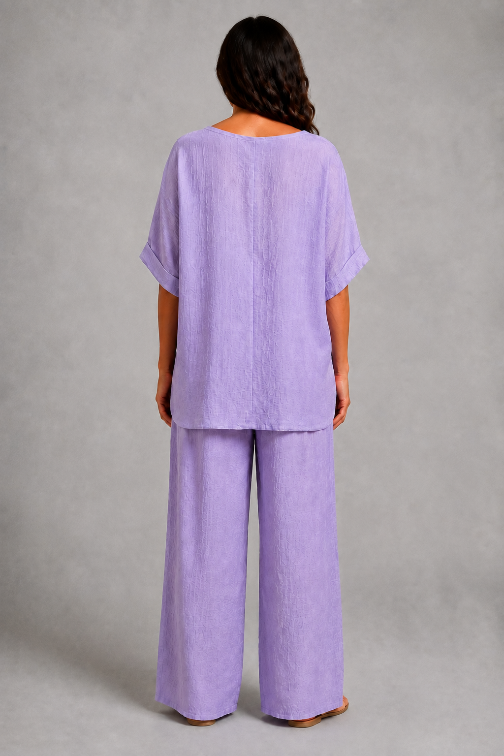 Lilac women’s co-ord set with a relaxed longline top, wide-leg trousers and coordinating statement pendant necklace.