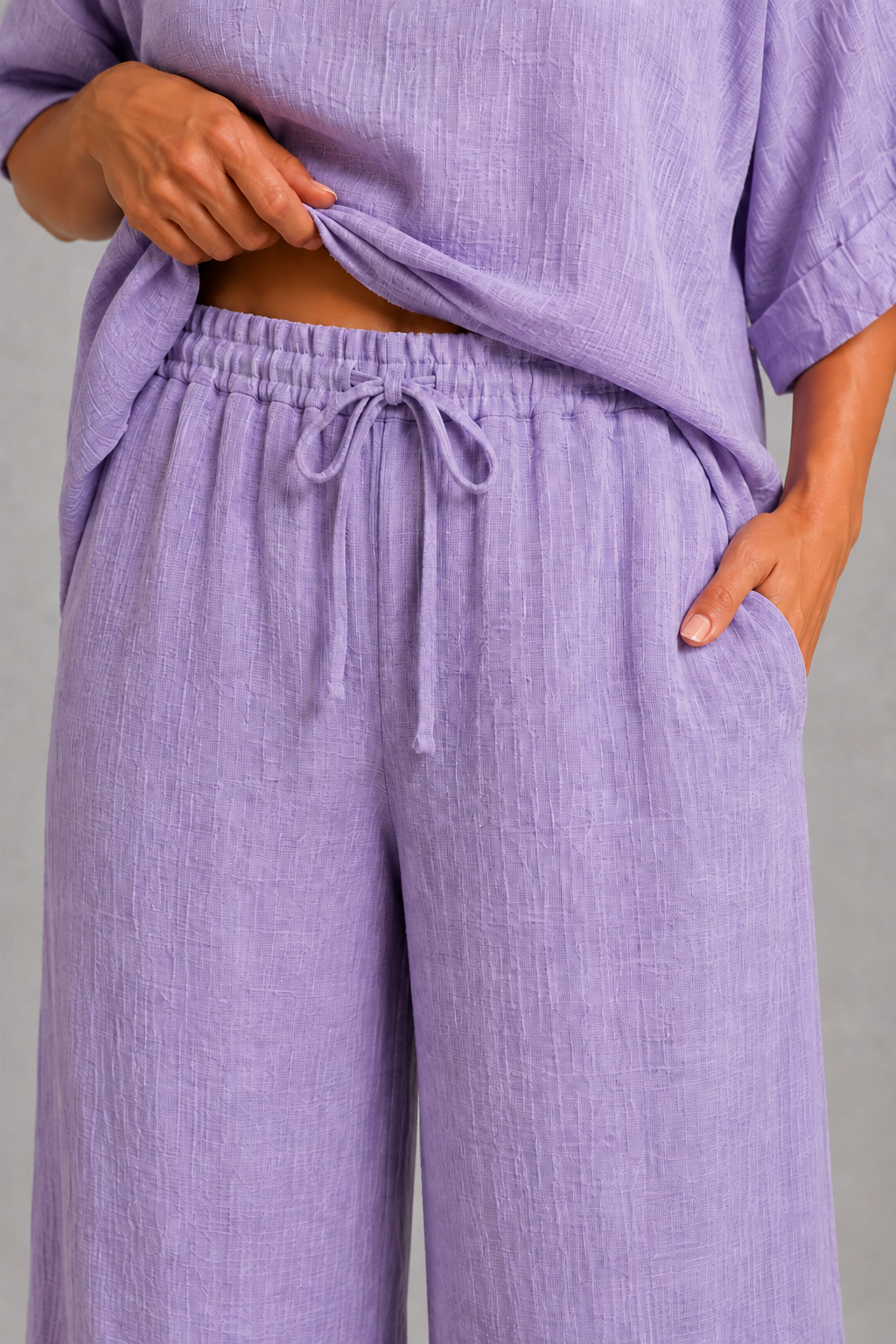 Lilac women’s co-ord set with a relaxed longline top, wide-leg trousers and coordinating statement pendant necklace.