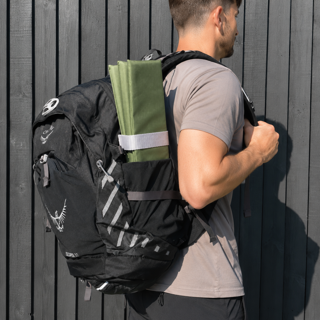 Olive Foldable waterproof camping sit mat with padded cushioning and an elastic carry strap for easy outdoor transport.