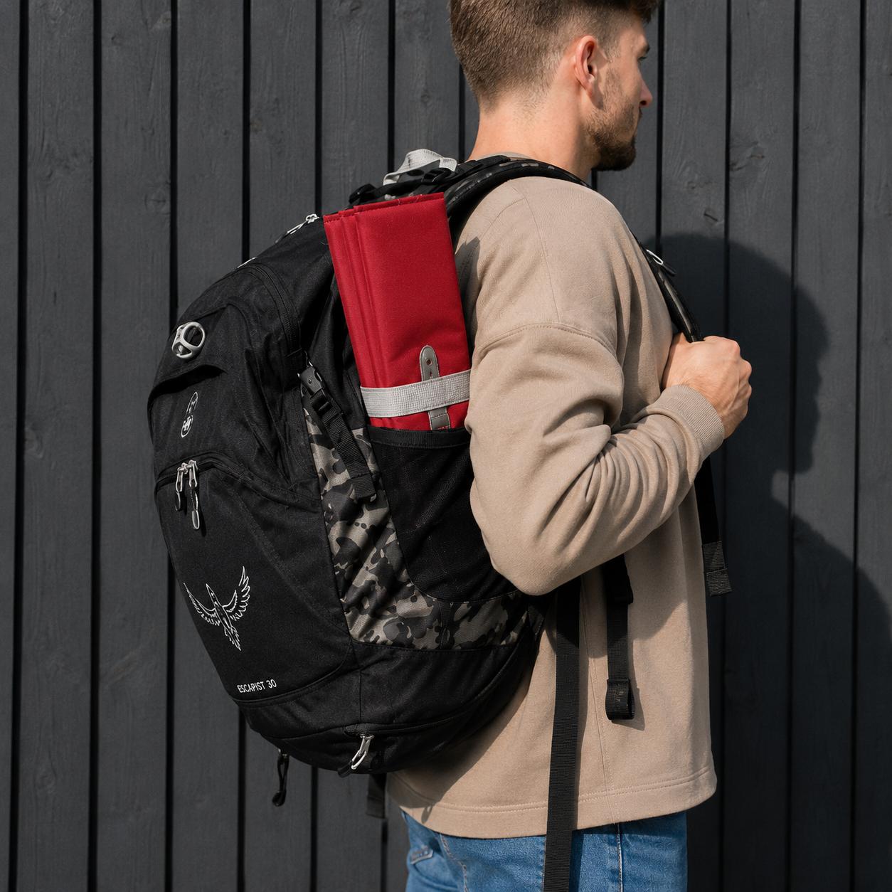 Red Foldable waterproof camping sit mat with padded cushioning and an elastic carry strap for easy outdoor transport.