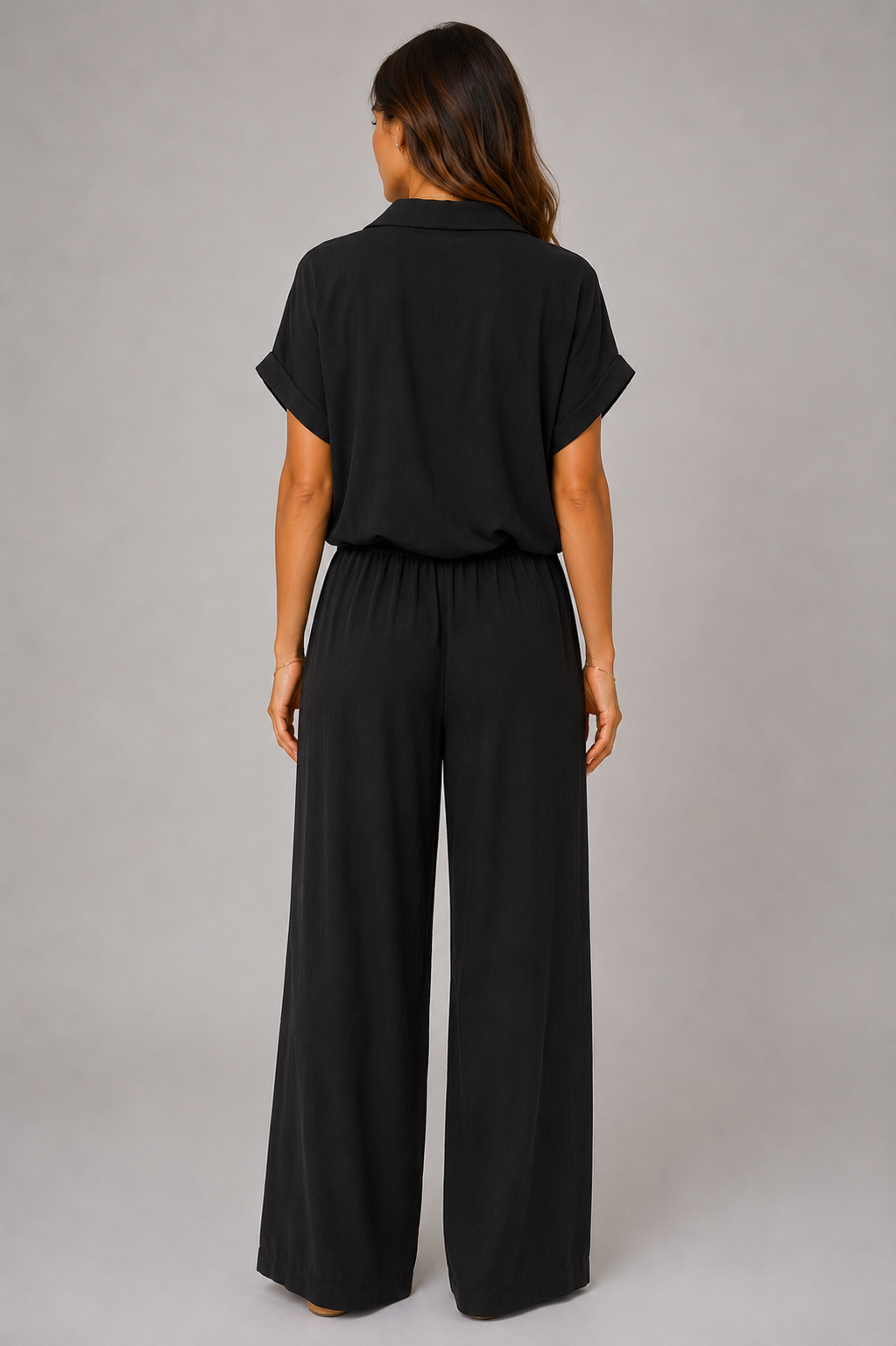 Woman modelling a Made in Italy two-piece lounge set in a soft textured fabric. The outfit features a relaxed short-sleeve collared shirt with button-front detail and a tie-front hem, paired with wide-leg elasticated waist trousers. Shown in multiple colours against a light grey studio background.