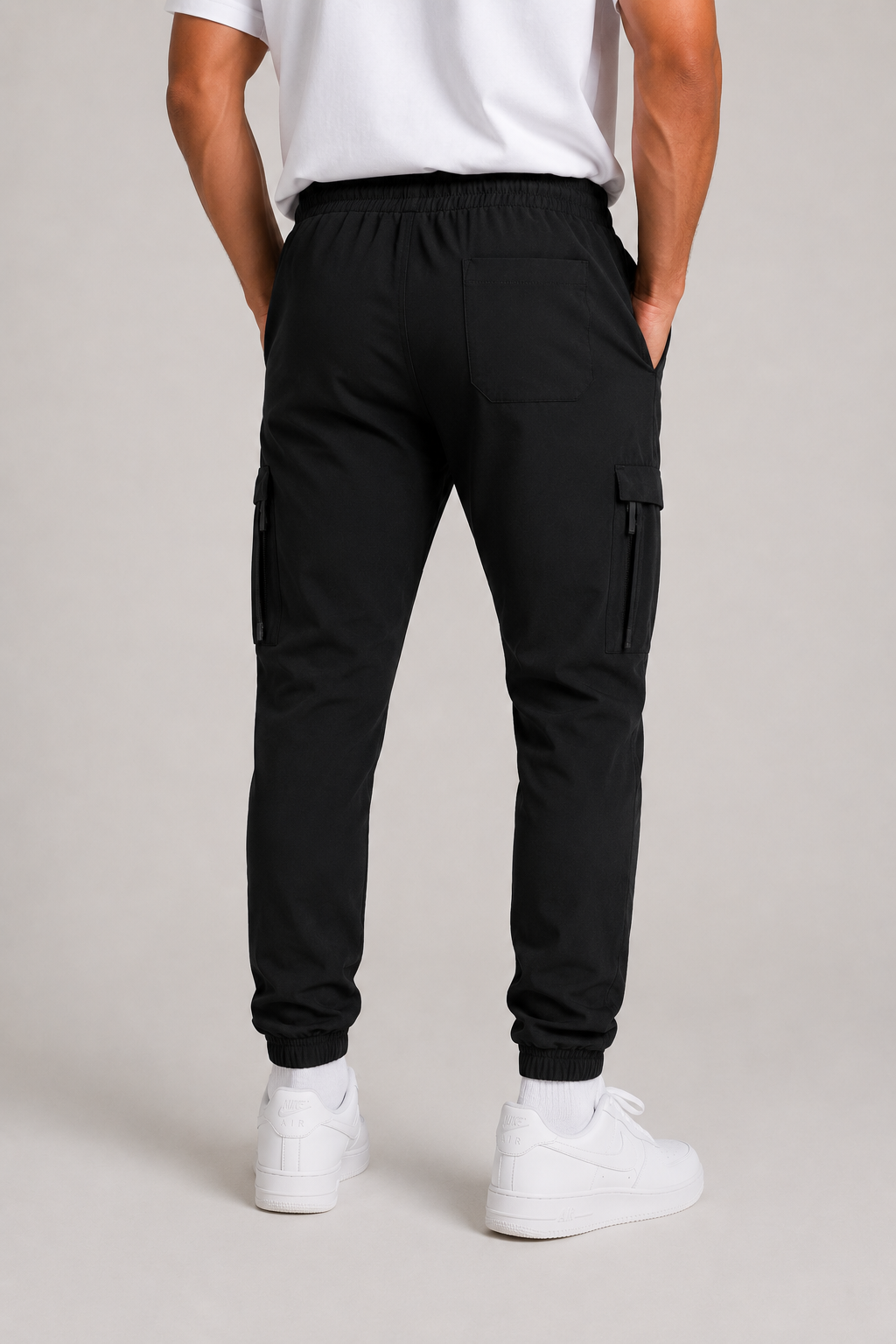 Men's slim fit black cargo trousers with side zip pocket, cuffed ankles, and elastic waistband