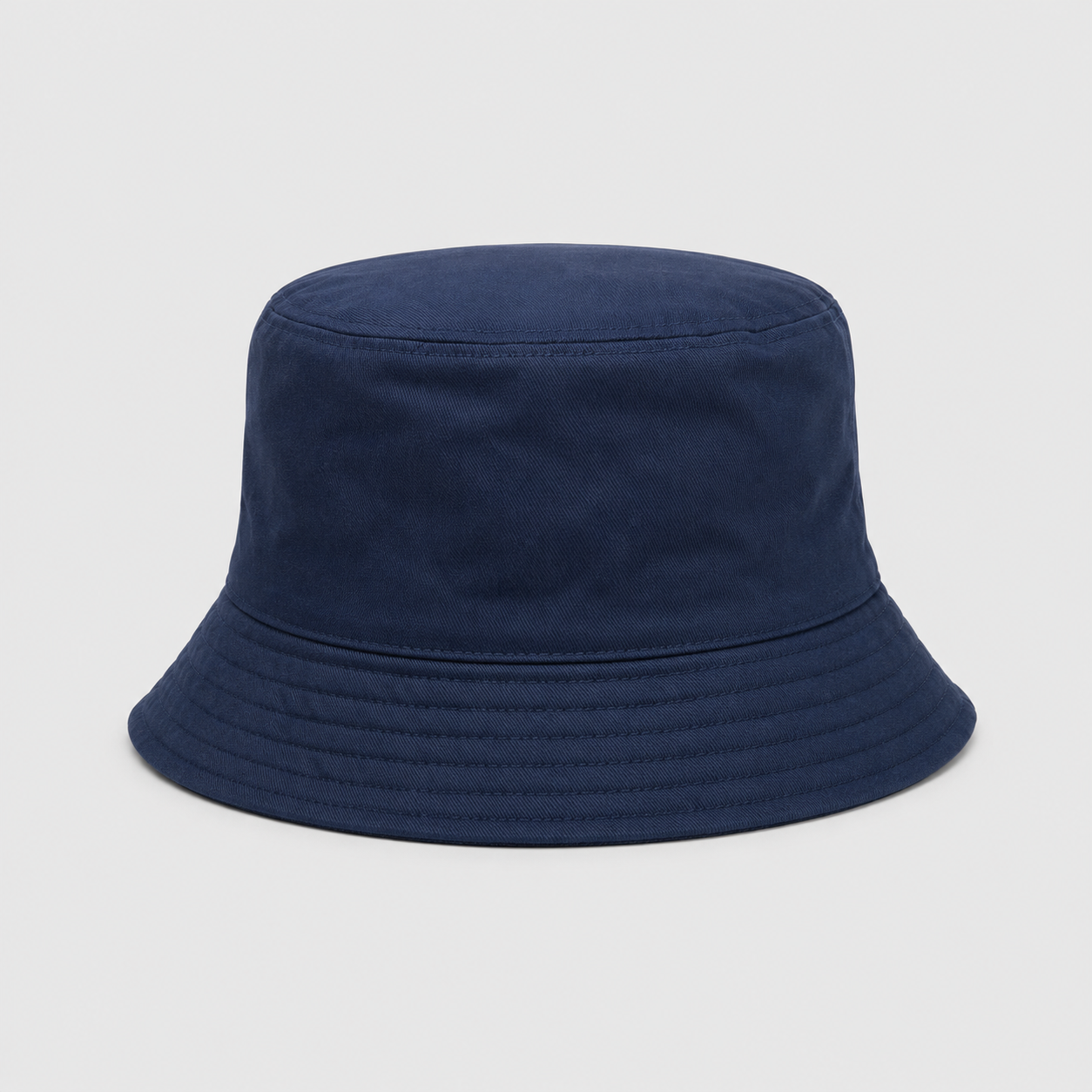 Kids reversible bucket hat with vibrant pink and orange tropical leaf print on one side and solid navy blue on the other, lightweight cotton sun hat for boys and girls.
