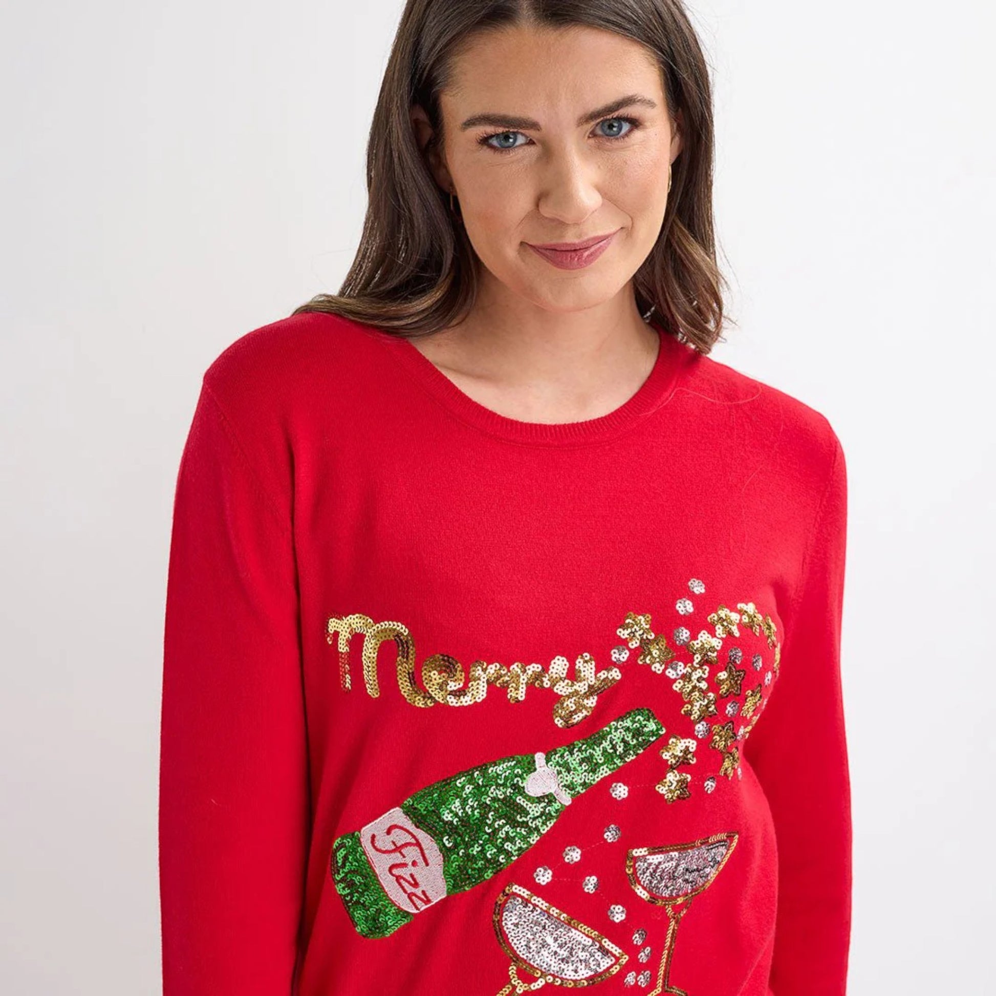 Ladies red Christmas jumper with sequin ‘Merry Fizzmas’ slogan, champagne bottle and glasses design, long sleeves and festive xmas style.
