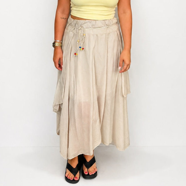 Ladies Italian boho maxi skirt in beige with an asymmetric hem, elasticated drawstring waistband and flowing relaxed fit.