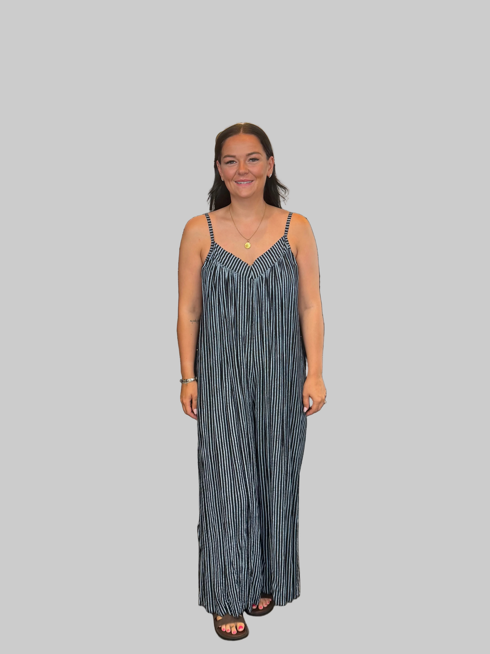 Women's Black and white striped wide leg jumpsuit with adjustable straps, modelled with a relaxed fit