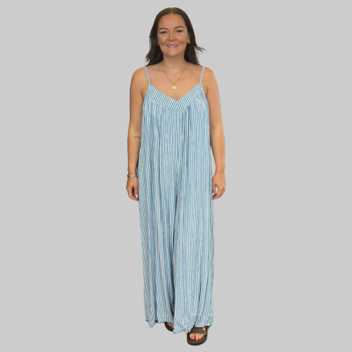 Women's blue and white striped wide leg jumpsuit with adjustable straps, modelled with a relaxed fit