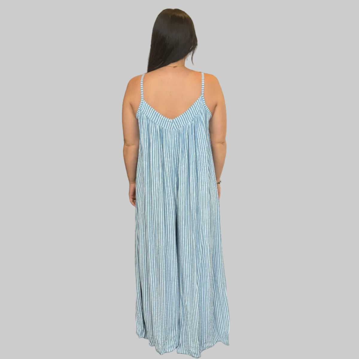 Women's blue and white striped wide leg jumpsuit with adjustable straps, modelled with a relaxed fit.