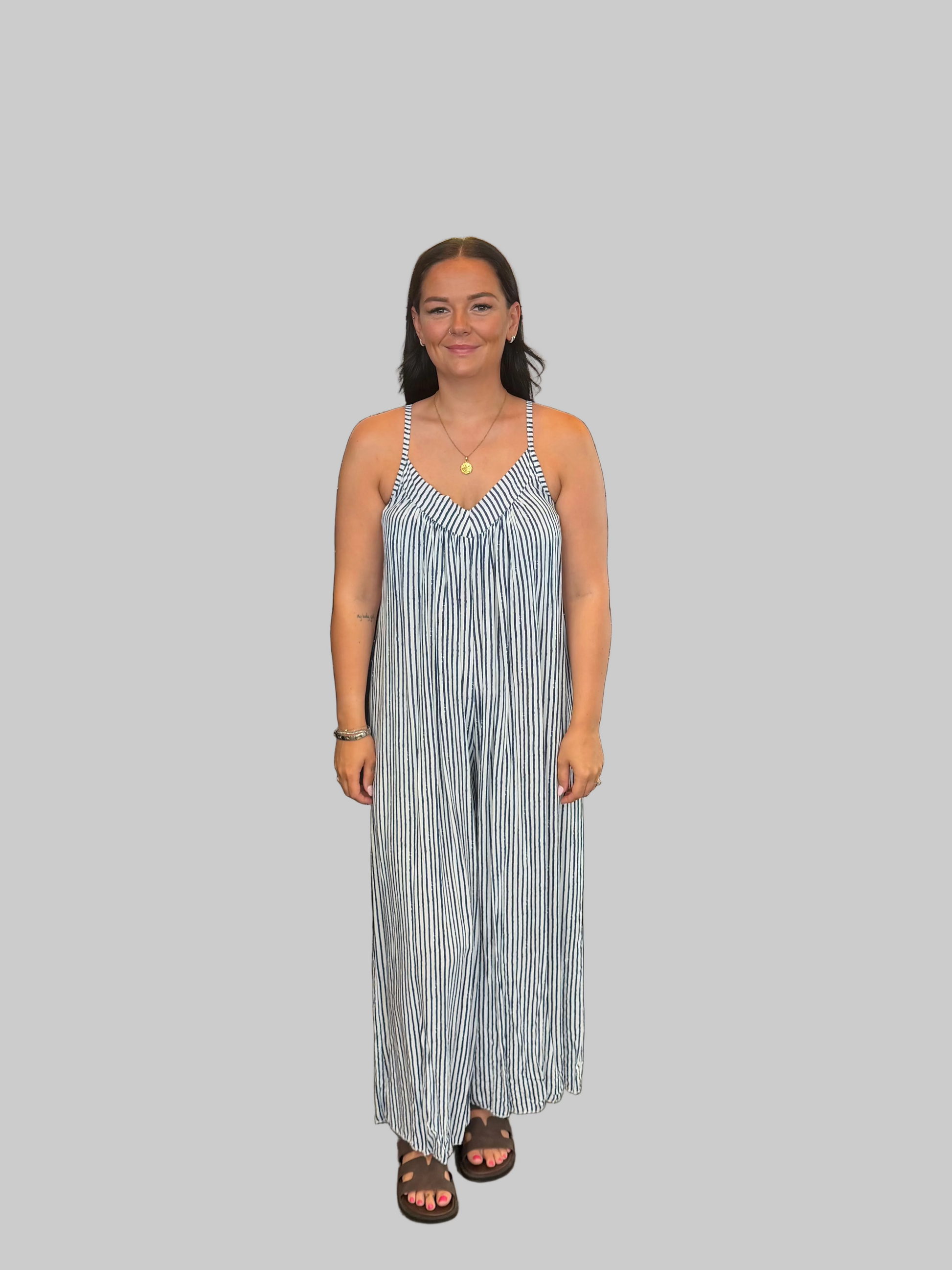 Women's Navy and white striped wide leg jumpsuit with adjustable straps, modelled with a relaxed fit.