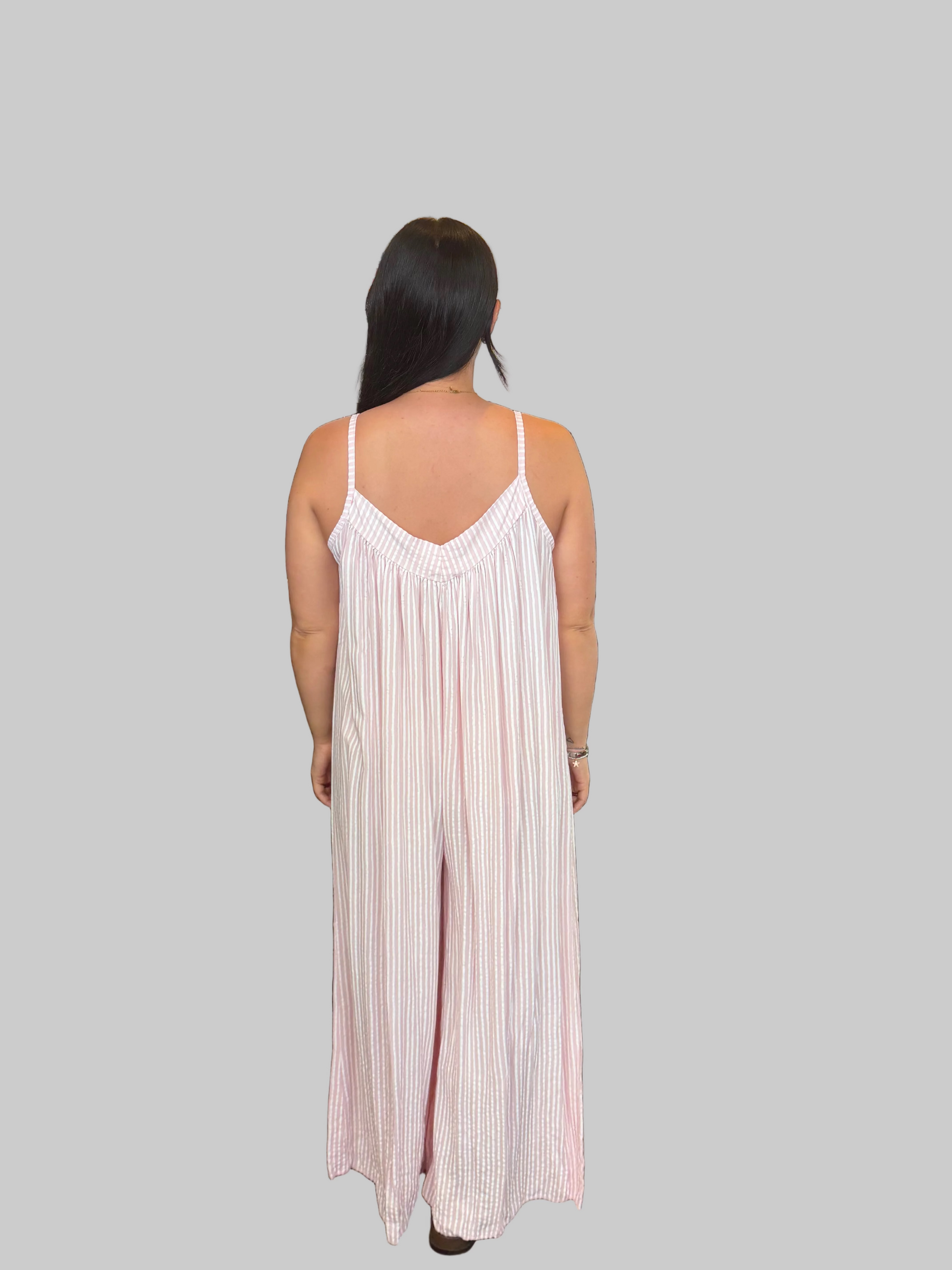 Women's Pink and white striped wide leg jumpsuit with adjustable straps, modelled with a relaxed fit