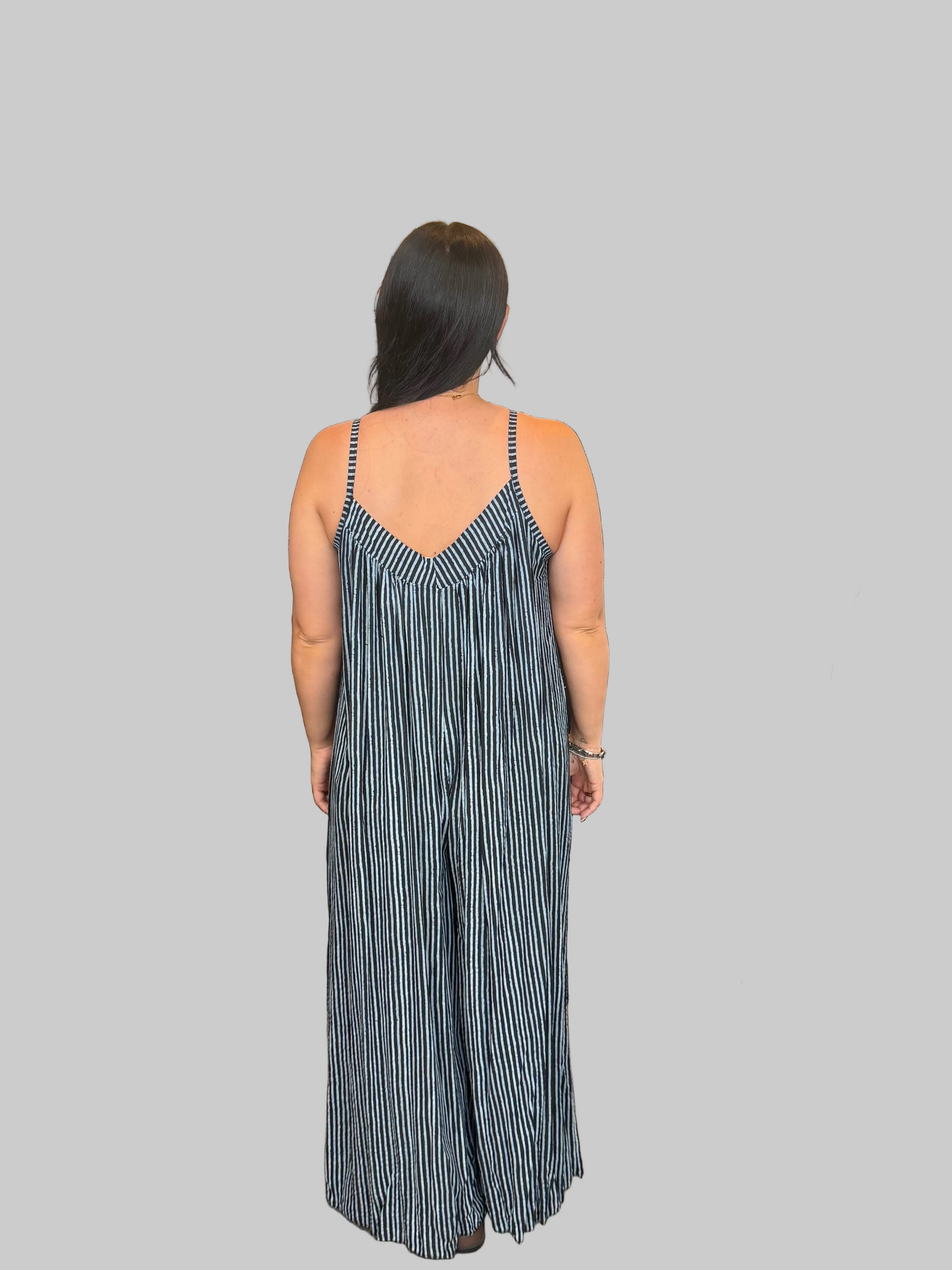 Women's Black and white striped wide leg jumpsuit with adjustable straps, modelled with a relaxed fit
