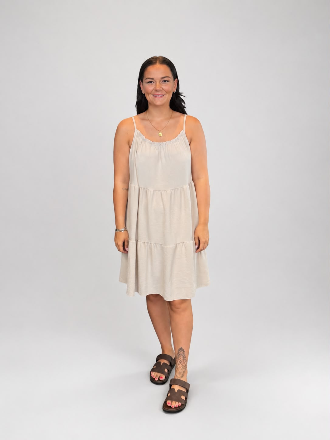 A versatile bagie tiered cami dress featuring spaghetti straps, a relaxed, flowy fit, and a flattering knee-length design. Lightweight and easy to wear, it's ideal for casual everyday styling, holidays, weekends, and warm-weather occasions.