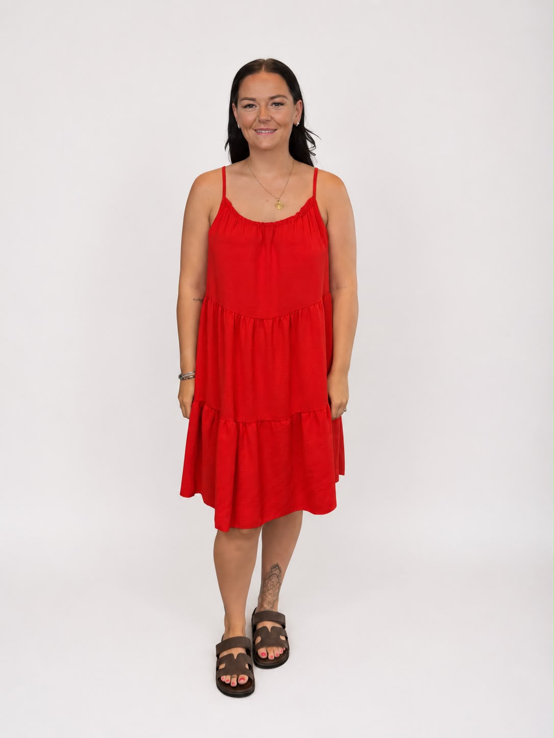 A versatile Red tiered cami dress featuring spaghetti straps, a relaxed, flowy fit, and a flattering knee-length design. Lightweight and easy to wear, it's ideal for casual everyday styling, holidays, weekends, and warm-weather occasions.