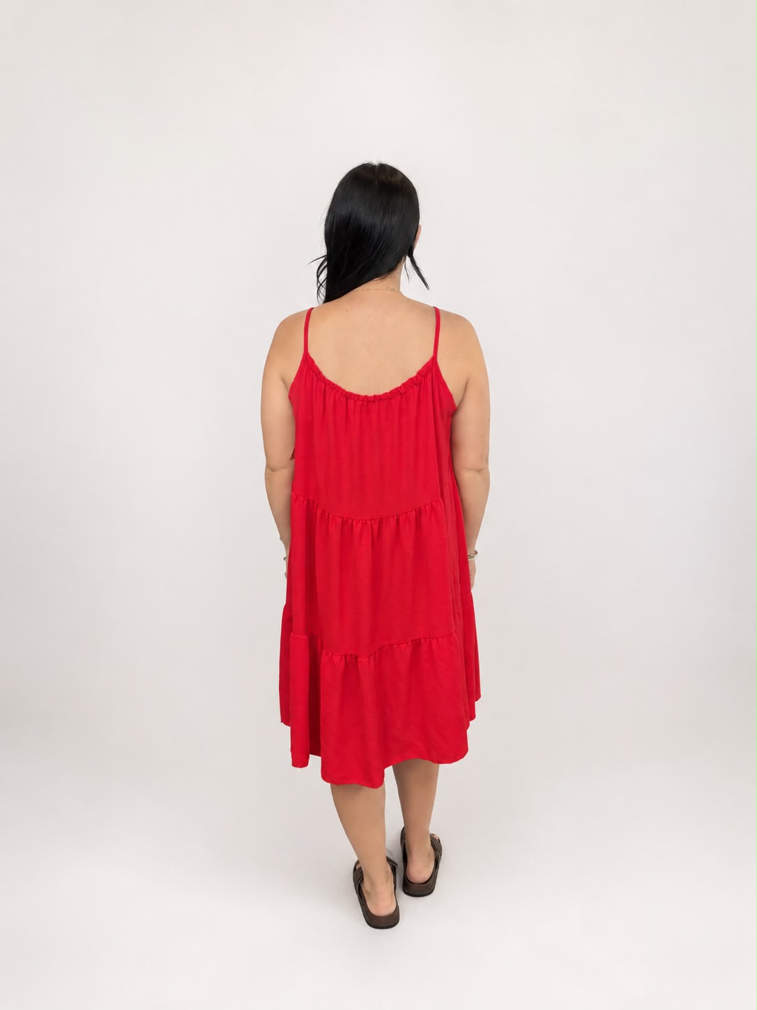 A versatile Red tiered cami dress featuring spaghetti straps, a relaxed, flowy fit, and a flattering knee-length design. Lightweight and easy to wear, it's ideal for casual everyday styling, holidays, weekends, and warm-weather occasions.