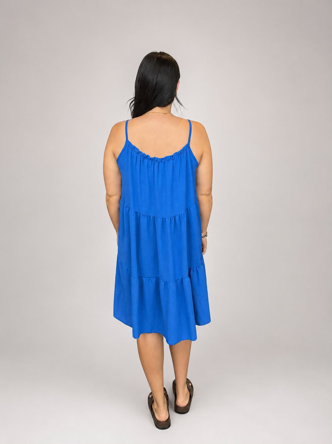 A versatile Royal Blue tiered cami dress featuring spaghetti straps, a relaxed, flowy fit, and a flattering knee-length design. Lightweight and easy to wear, it's ideal for casual everyday styling, holidays, weekends, and warm-weather occasions.
