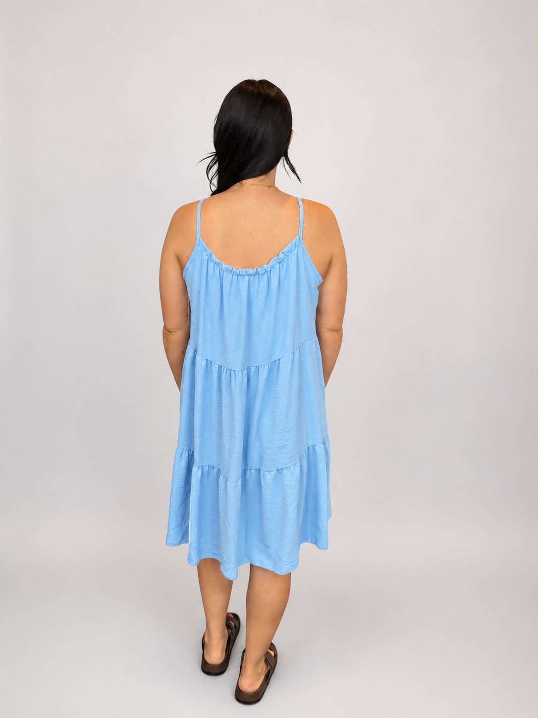 A versatile Light Blue tiered cami dress featuring spaghetti straps, a relaxed, flowy fit, and a flattering knee-length design. Lightweight and easy to wear, it's ideal for casual everyday styling, holidays, weekends, and warm-weather occasions.