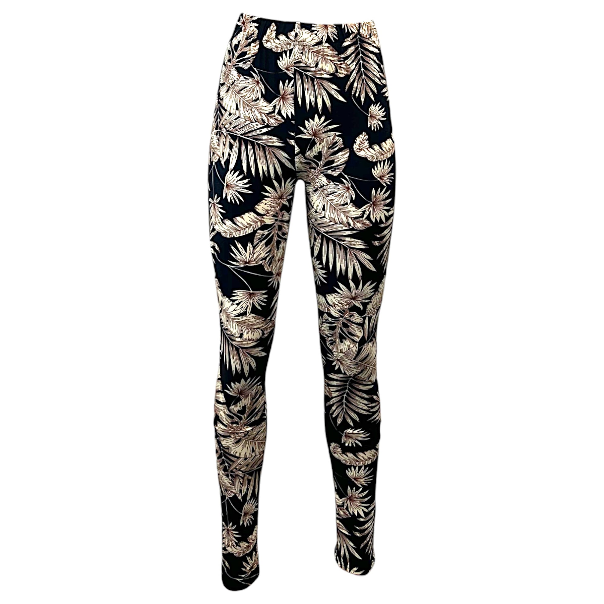 Women's black leggings with beige tropical leaf print, full-length stretch fit.