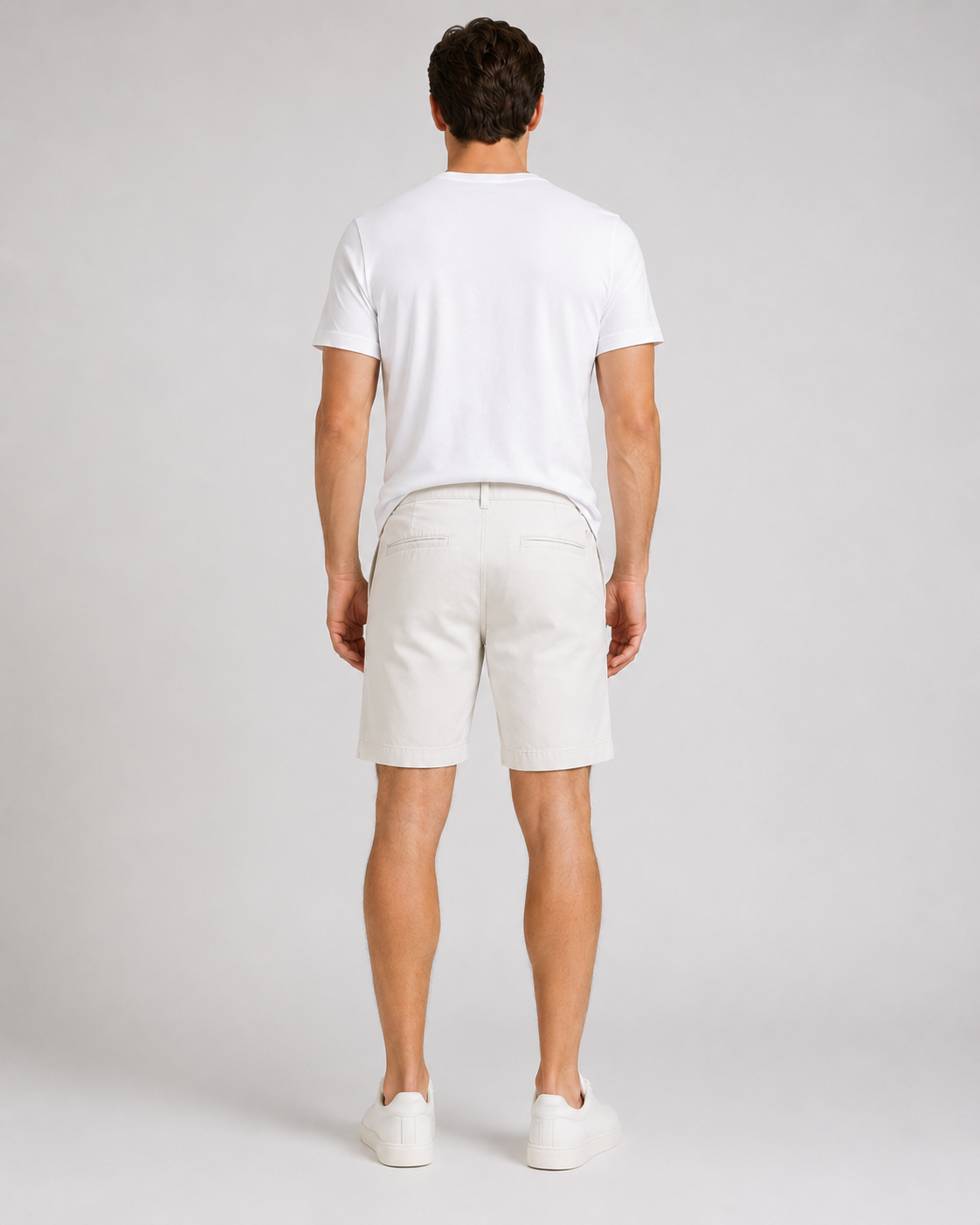 Men's white chino shorts styled with white crew neck t-shirt and sneakers
