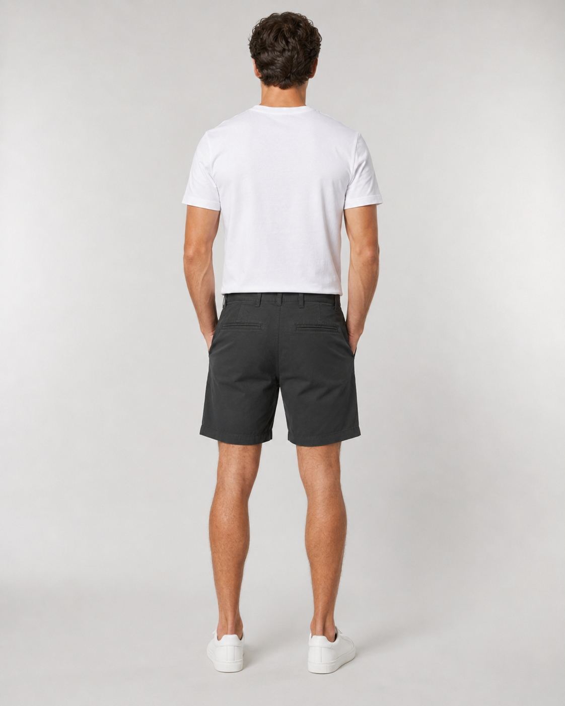 Men's black chino shorts paired with white t-shirt and white sneakers