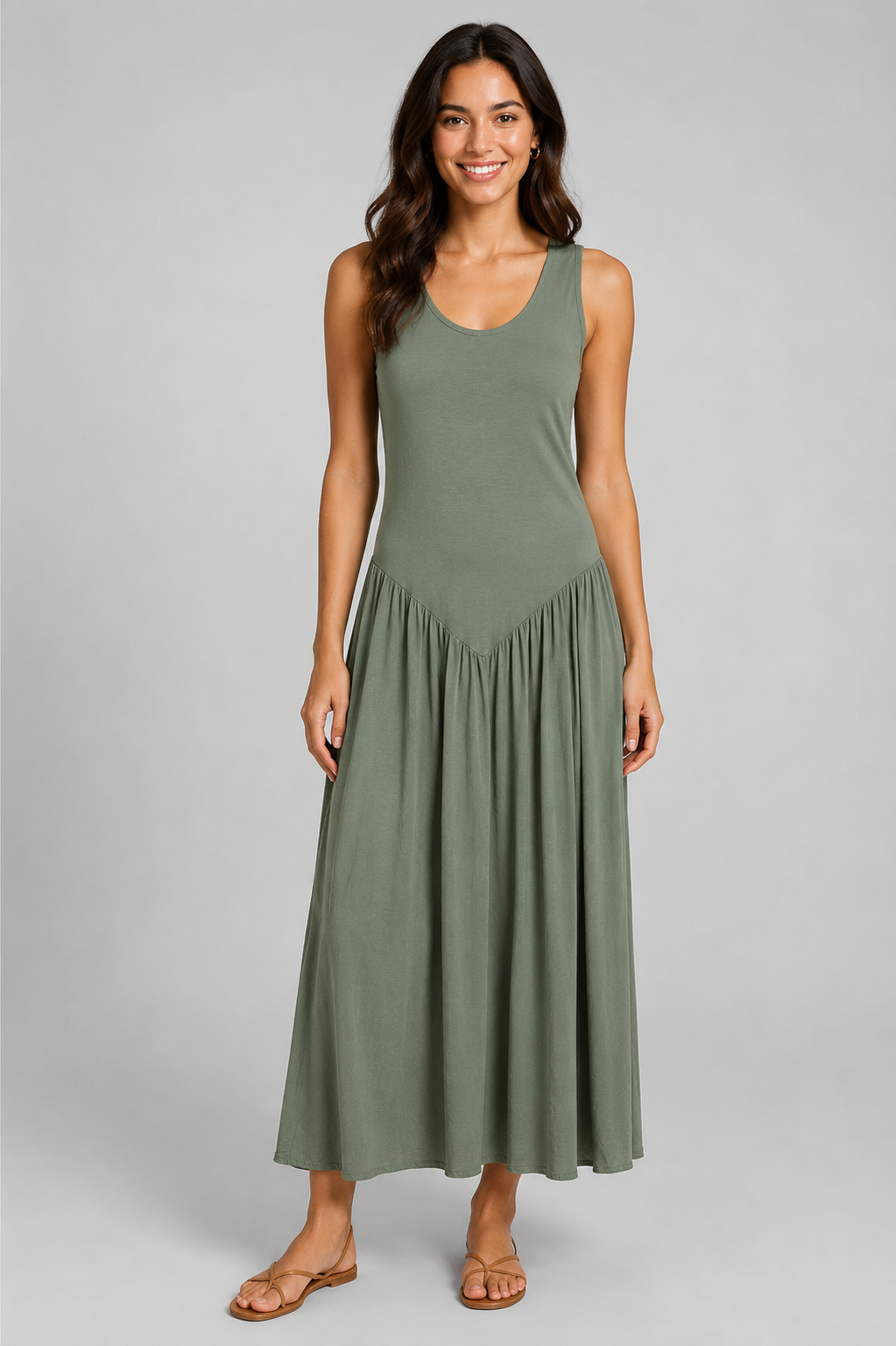Women's sleeveless maxi dress featuring a scoop neckline, fitted bodice, and flowing gathered skirt. Shown in a soft brown jersey fabric with a relaxed silhouette and maxi length, styled on a model against a light grey studio background.