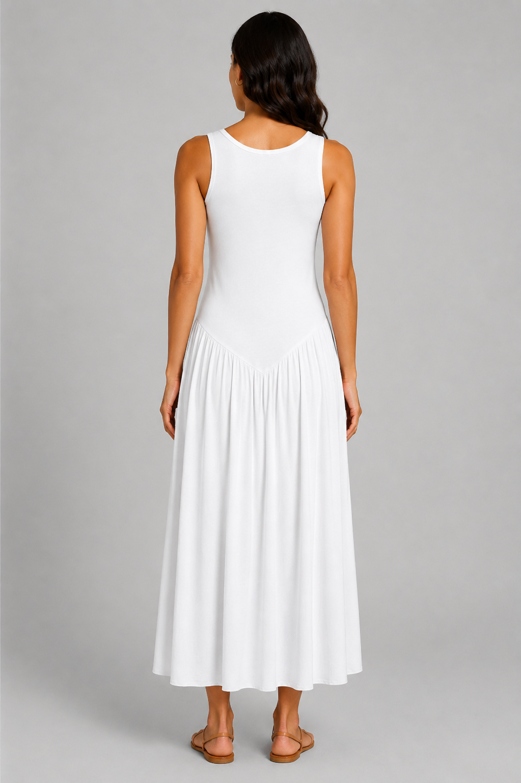 Women's sleeveless maxi dress featuring a scoop neckline, fitted bodice, and flowing gathered skirt. Shown in a soft brown jersey fabric with a relaxed silhouette and maxi length, styled on a model against a light grey studio background.
