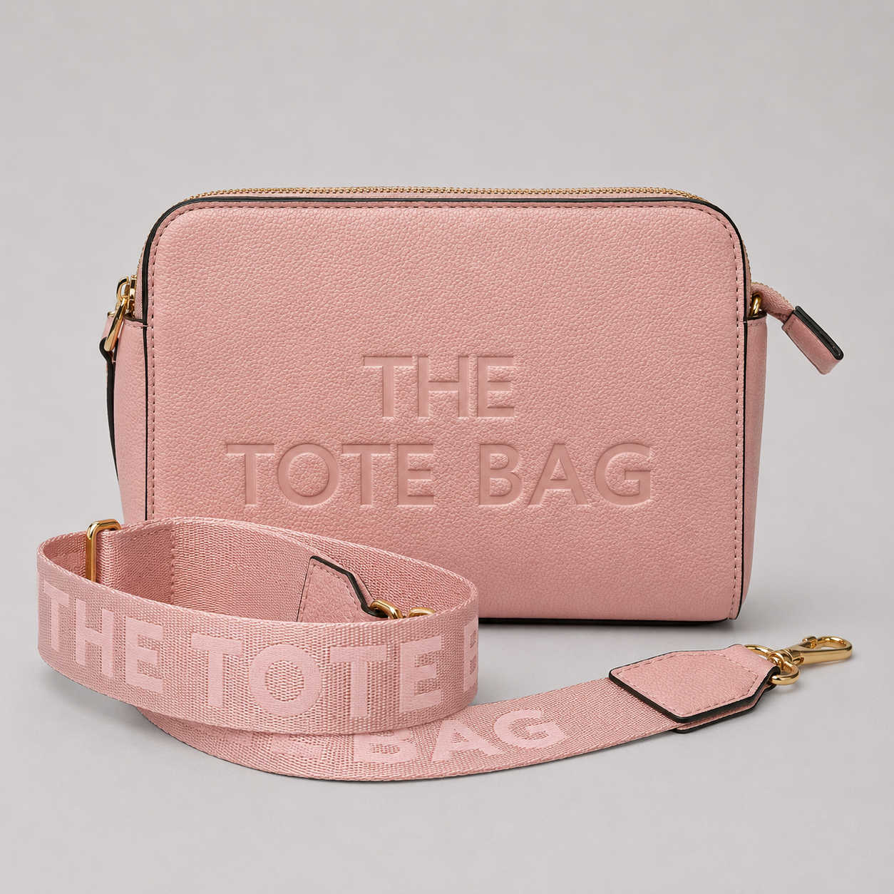 The Tote Bag crossbody bag with adjustable branded strap and gold hardware.
