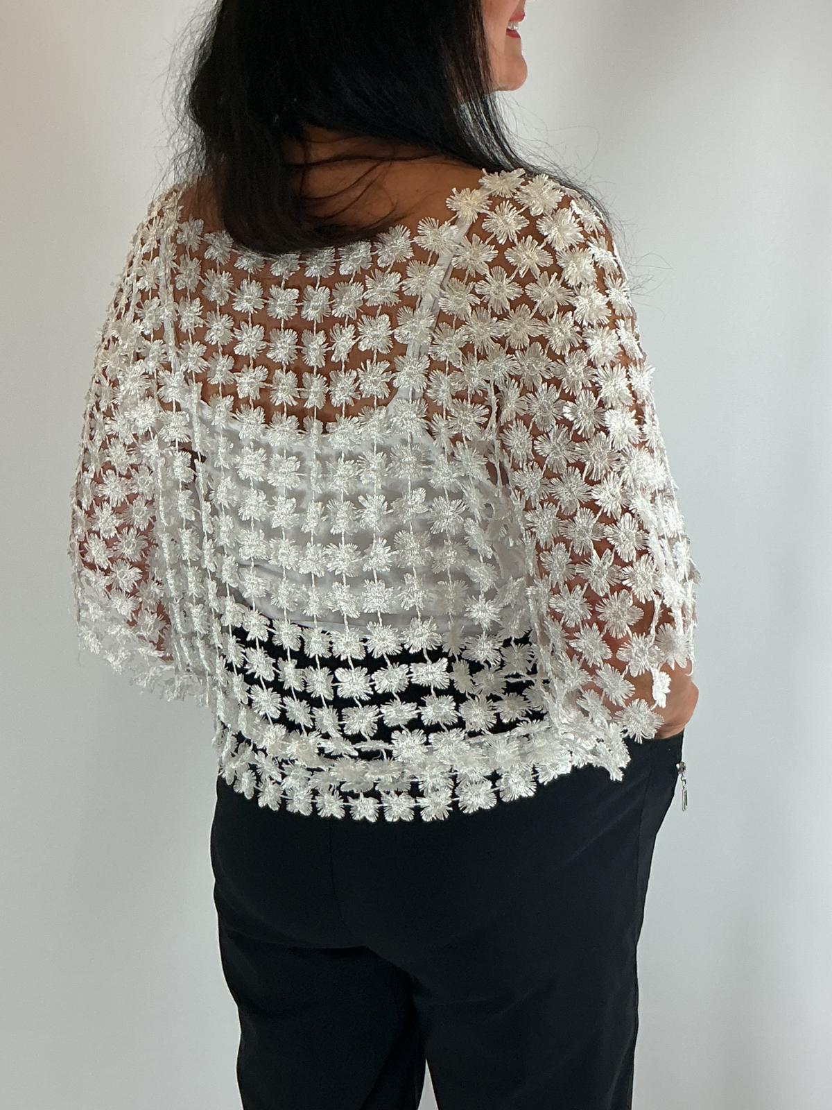 Ladies white semi-sheer floral embroidered top with short sleeves, a relaxed fit and scalloped edges