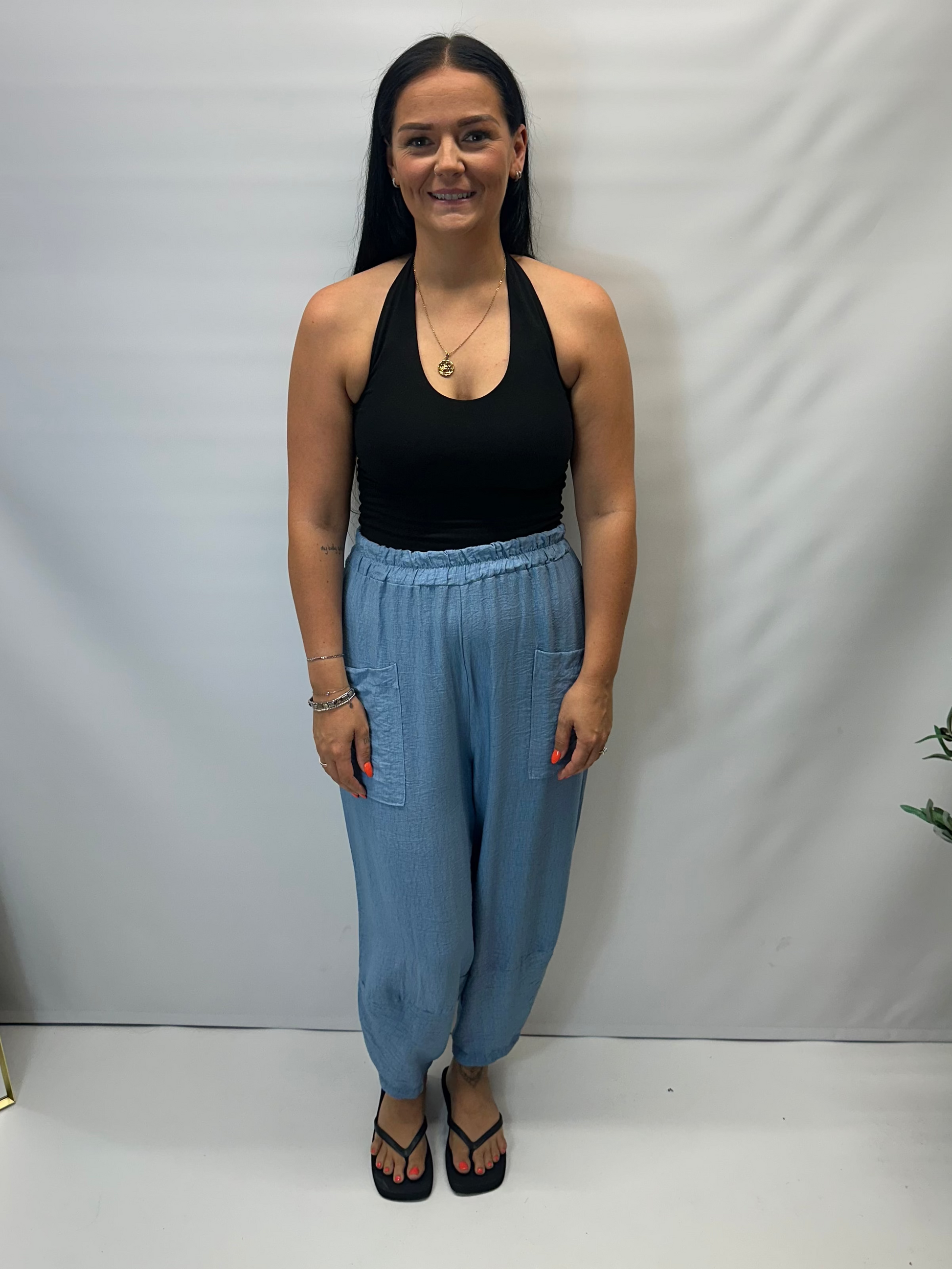 Model wearing Sky Blue Italian relaxed tapered trousers with an elasticated waistband, front patch pockets and crossover split hem detail.