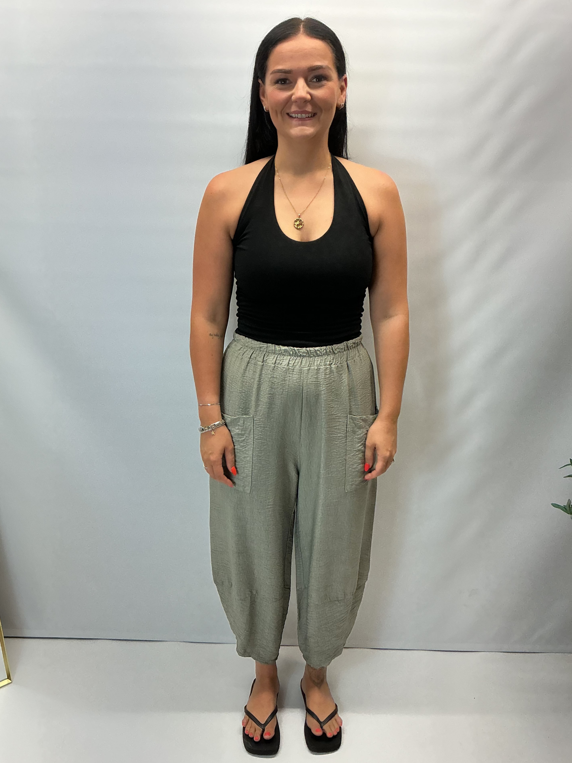 Model wearing khaki Italian relaxed tapered trousers with an elasticated waistband, front patch pockets and crossover split hem detail.