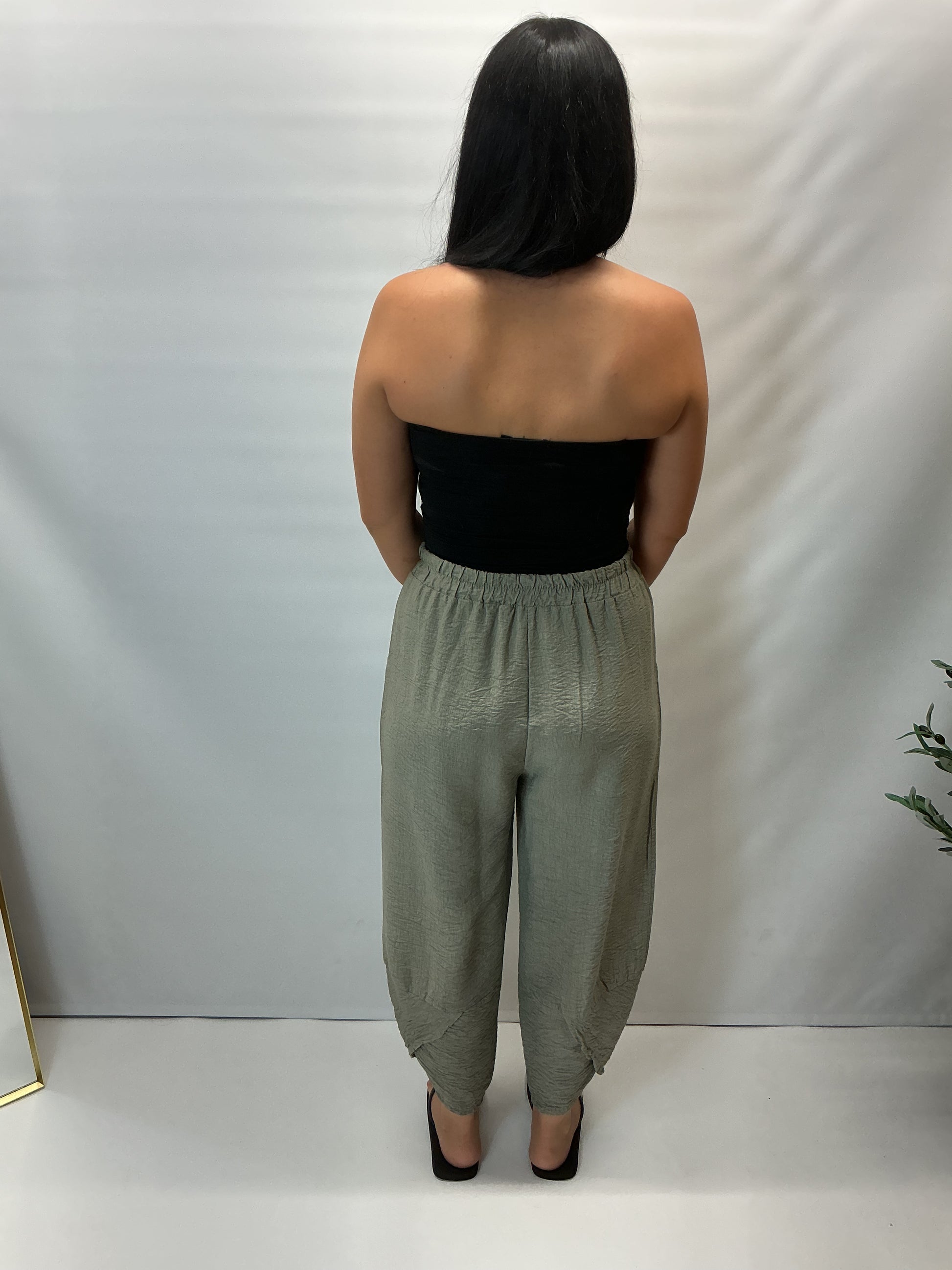 Model wearing khaki Italian relaxed tapered trousers with an elasticated waistband, front patch pockets and crossover split hem detail.