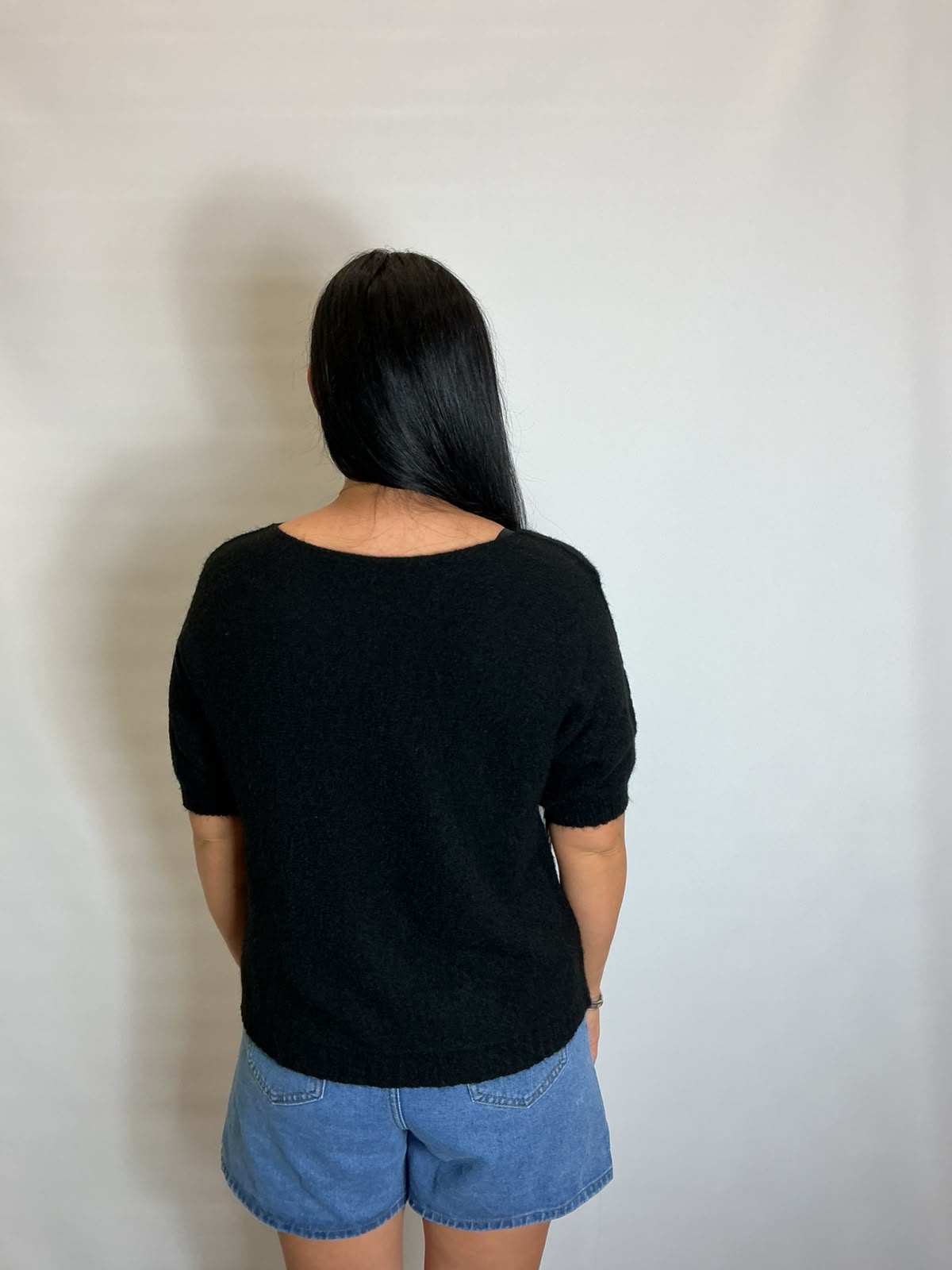 Women’s Black short-sleeve relaxed knit jumper with a wide round neckline and ribbed cuffs and hem.